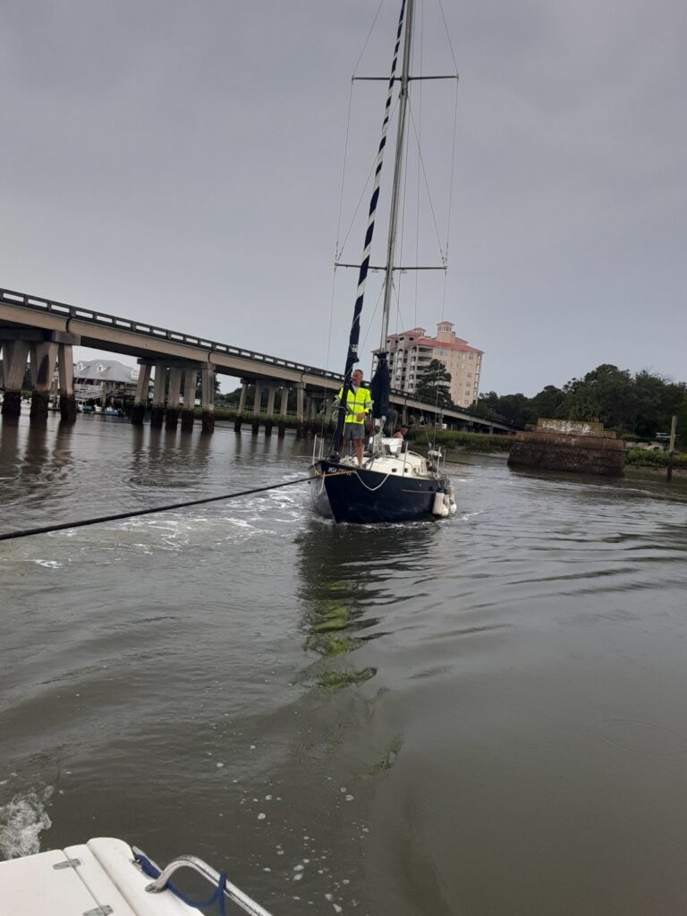 Sailboat being towed on water for disposal